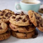 Brown butter chocolate chip cookies next to a cup of coffee.