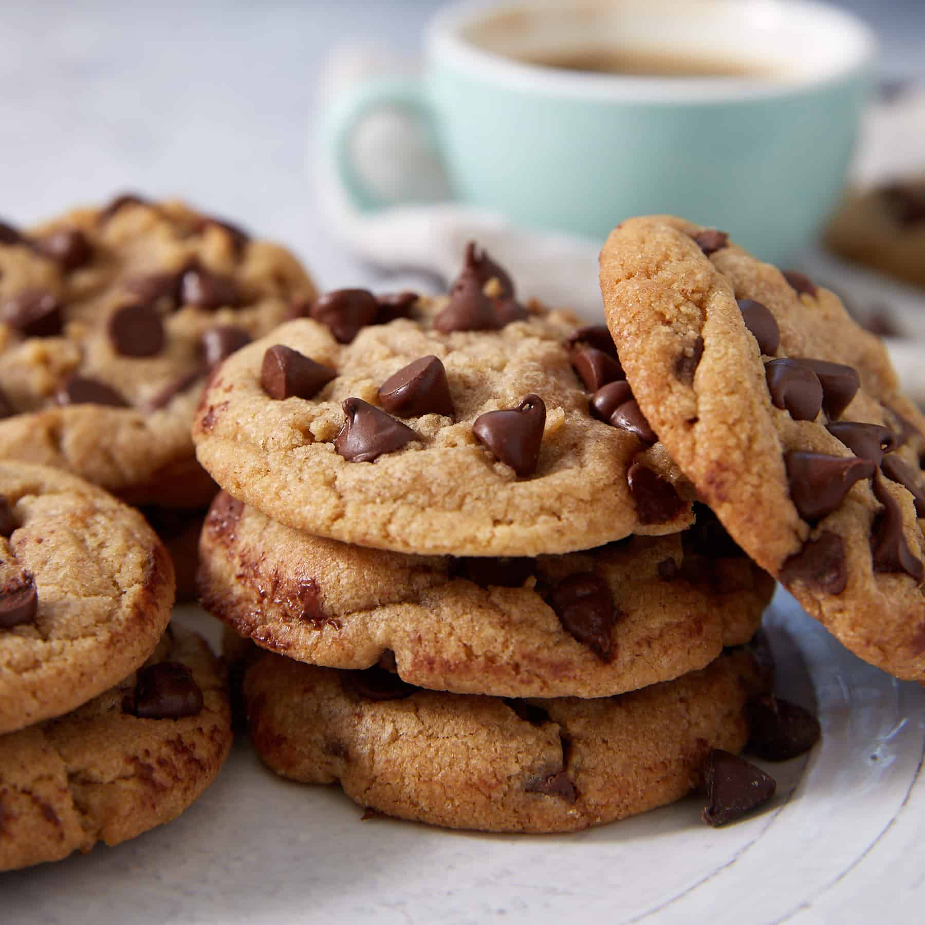 Brown butter chocolate chip cookies next to a cup of coffee.