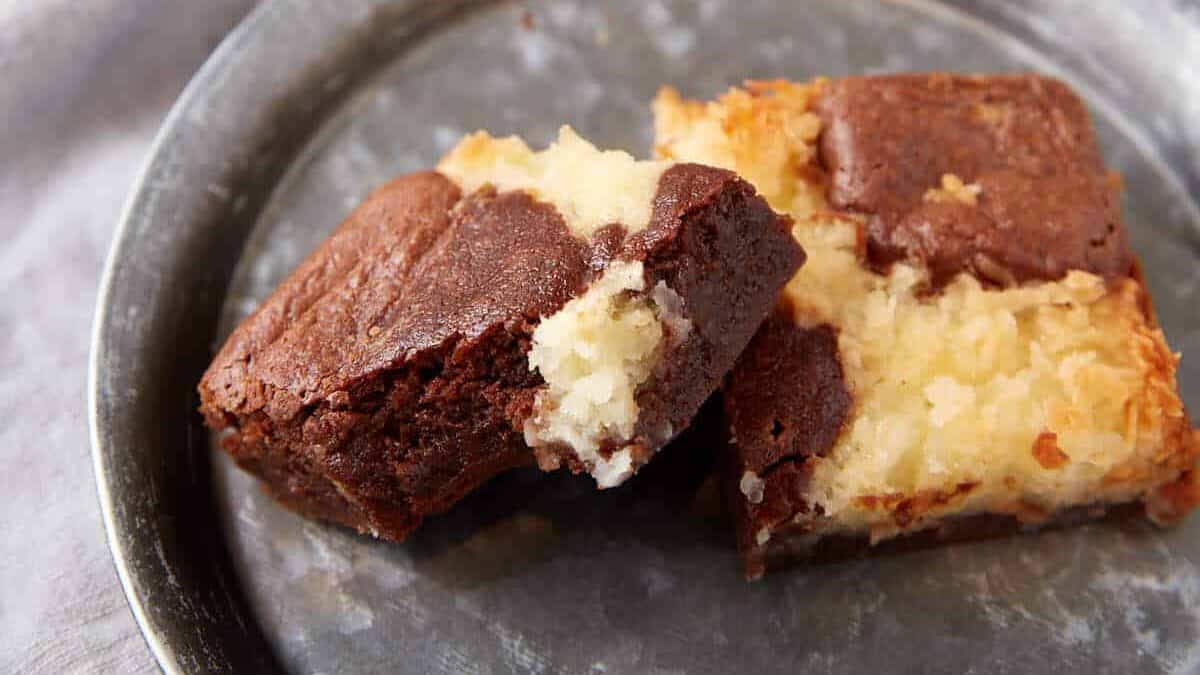 Two coconut brownies on a dessert plate.