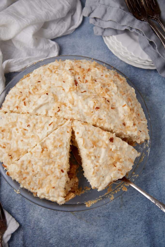 a slice of coconut cream pie being taken out.