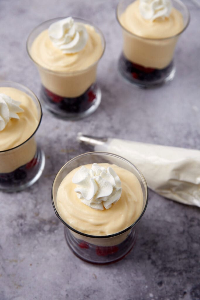 whipped topping piped onto lemon mousse in dessert cups.