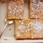 Paula Deen butter cake in a baking dish with a serving spoon.