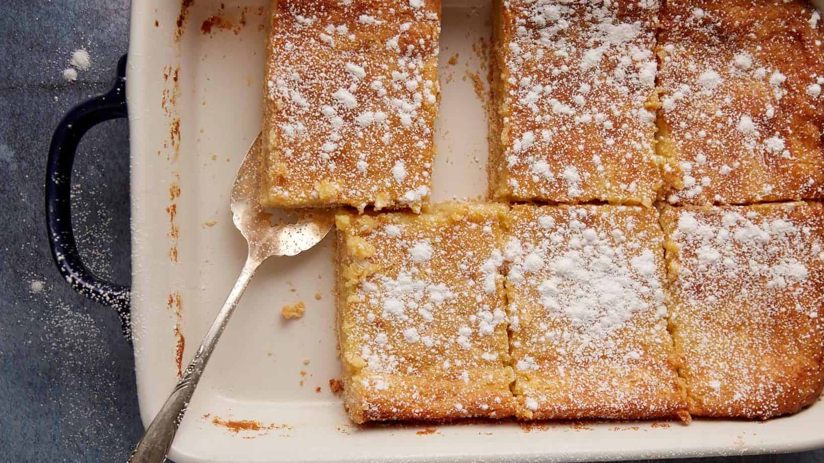 Paula Deen butter cake in a baking dish with a serving spoon.
