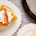 slices of peach cheesecake on white plates.