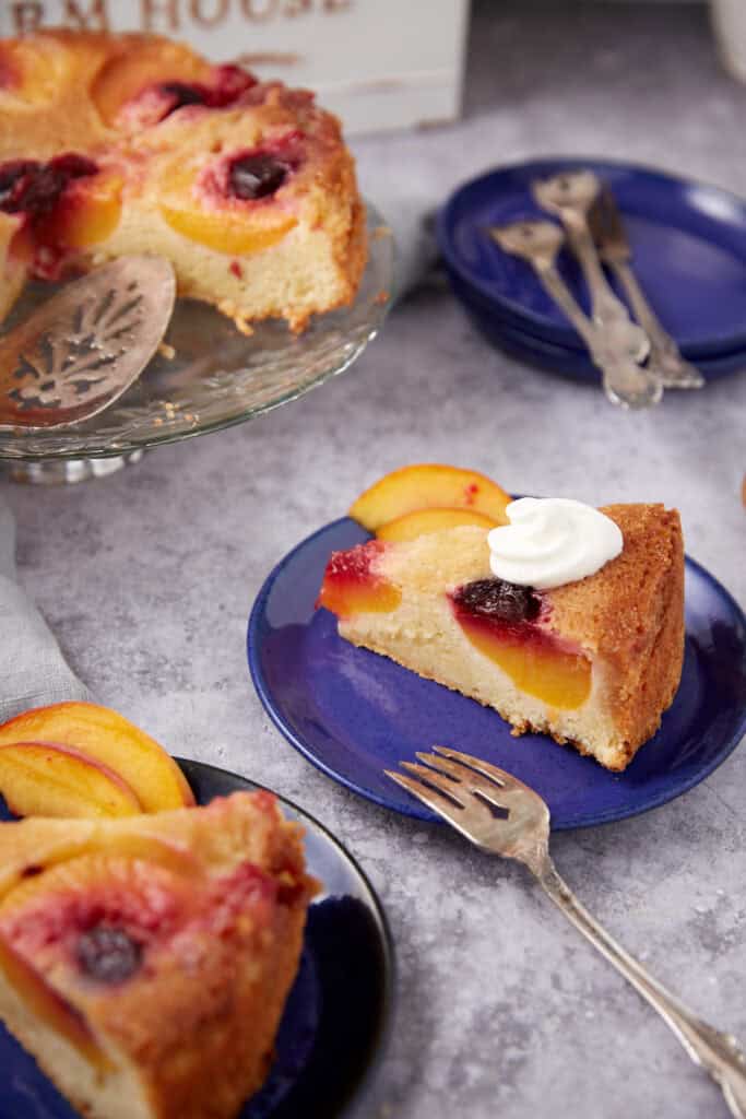 a piece of peach upside down cake on a blue plate.