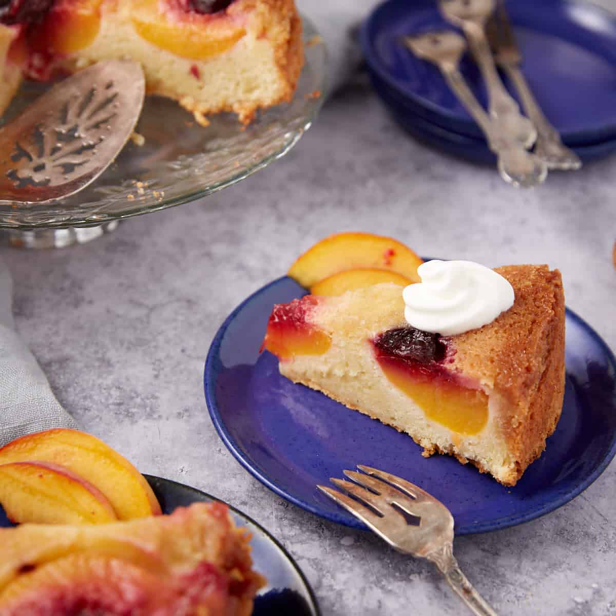 a piece of peach upside down cake on a blue plate.