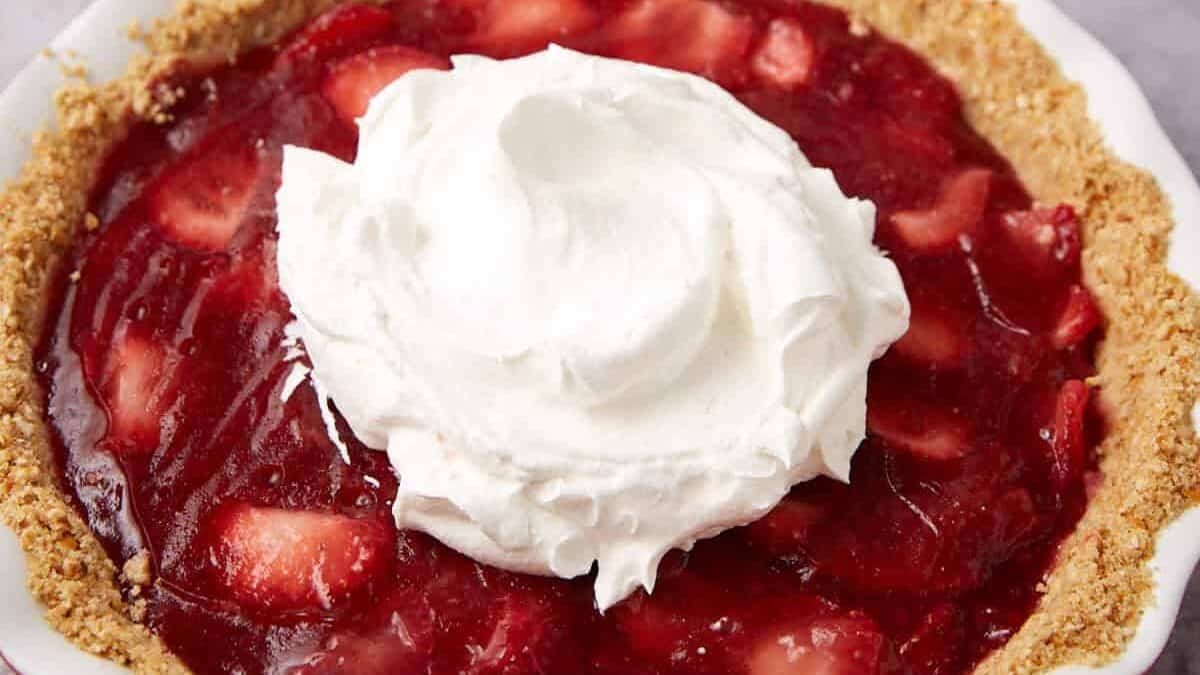 A strawberry icebox pie with whipped cream on top.