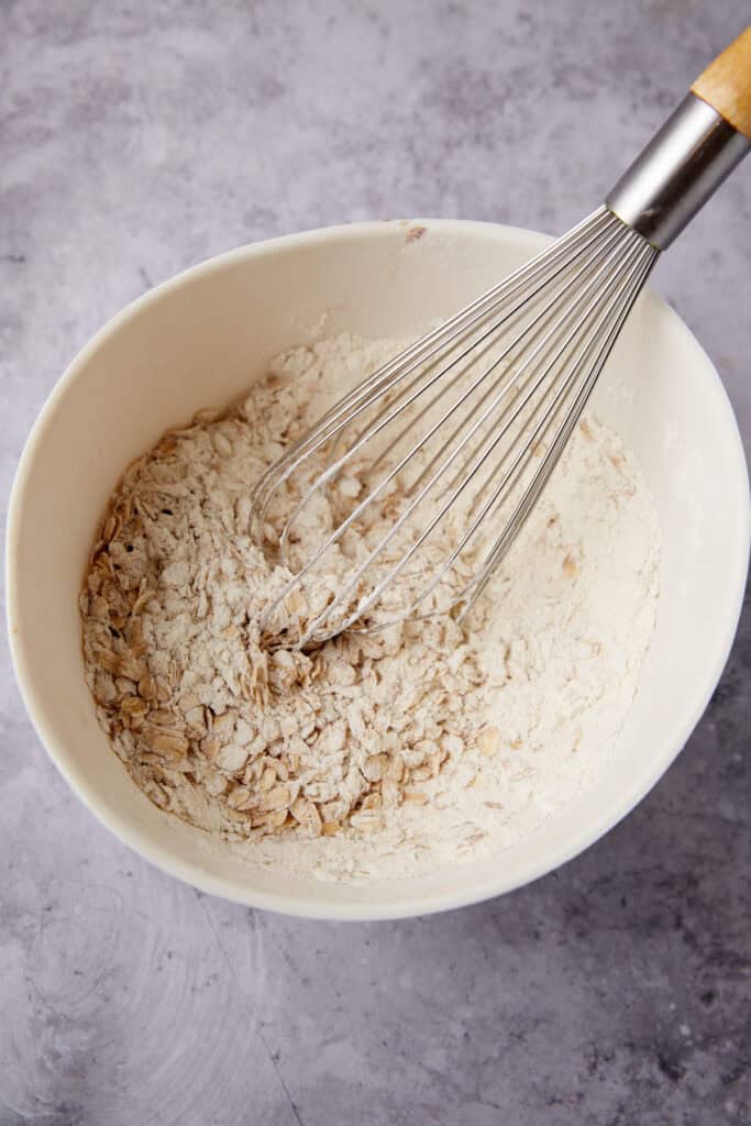 dry ingredients being whisked in a white bowl.