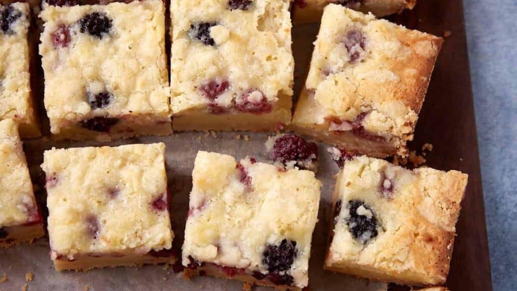 sliced fruit crumble bars on a baking sheet.