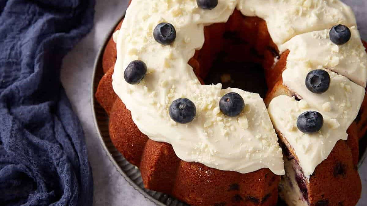 A slice being removed from a blueberry cake.