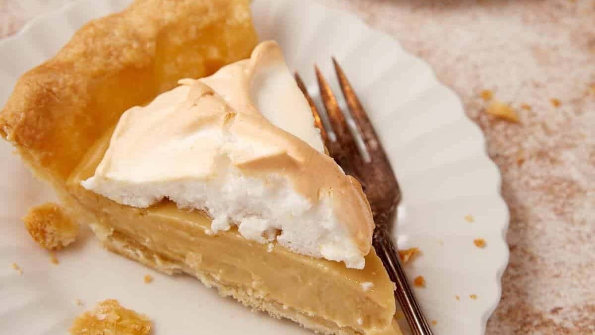 slice of butterscotch pie on a white plate with a fork.