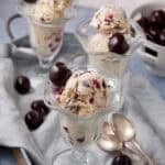 cherry chocolate ie cream in a clear serving dish garnished with fresh cherries.