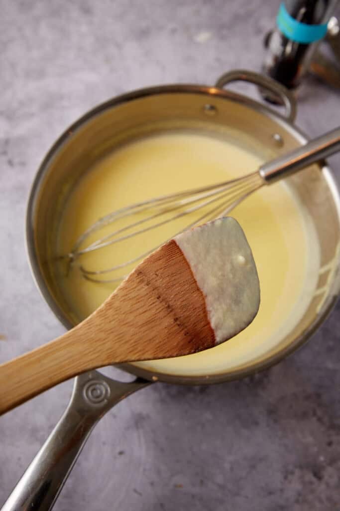 custard coating the back of a wooden spoon to show thickness.