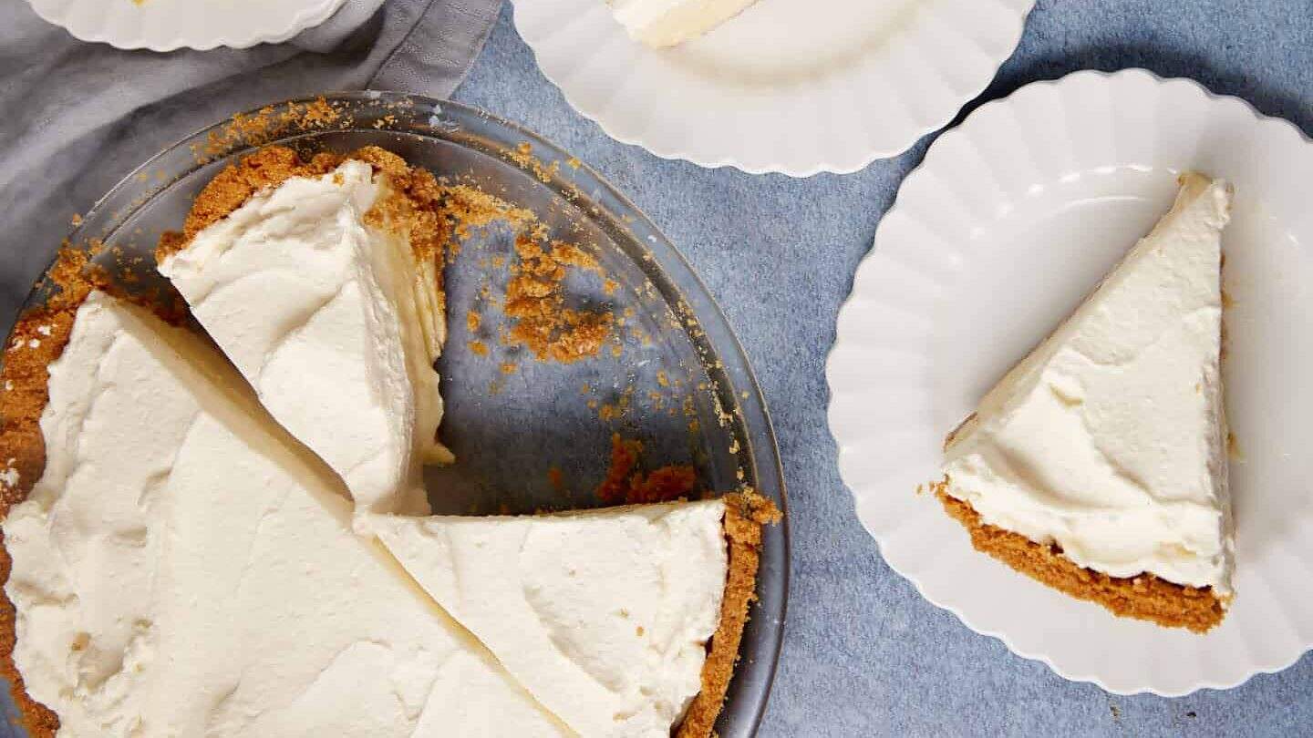 Two slices of lemon pie on plates next to a pie dish.