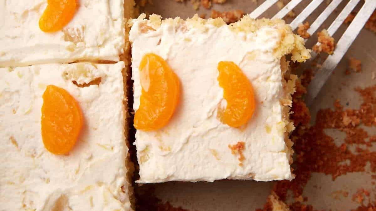 sliced mandarin orange cake with a slice being taken out.