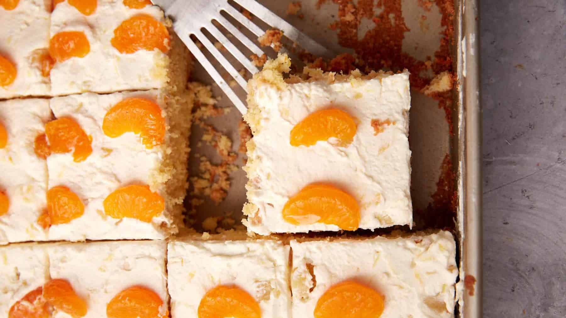 sliced mandarin orange cake with a slice being taken out.