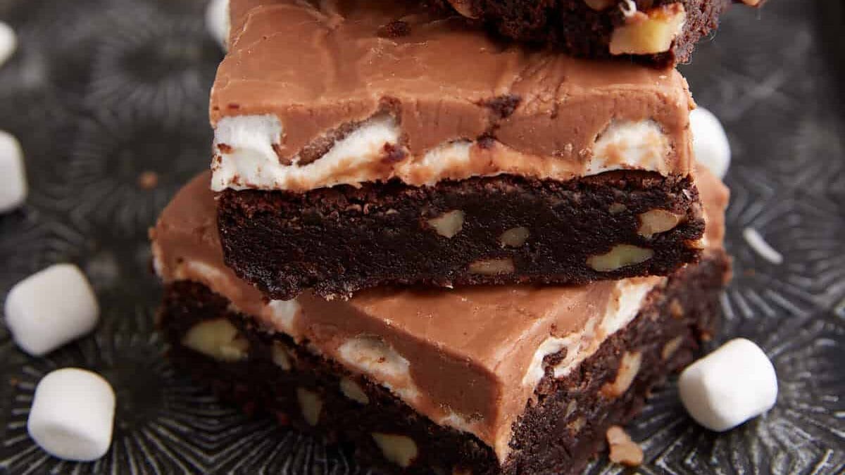 Three brownies stacked on a tray.