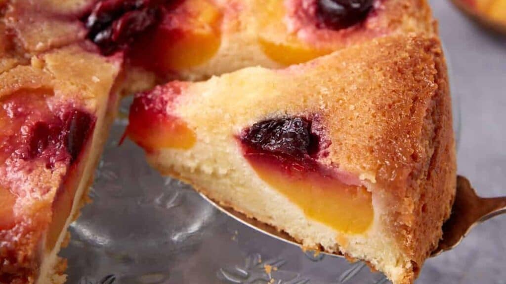 peach upside down cake with a piece being taken out it.