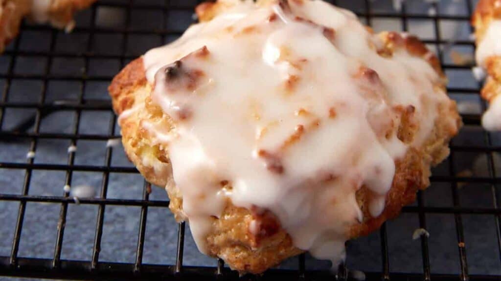 A batch of apple fritters on a wire rack.