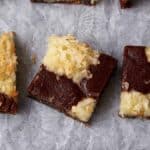 A batch of coconut brownies on parchment paper.