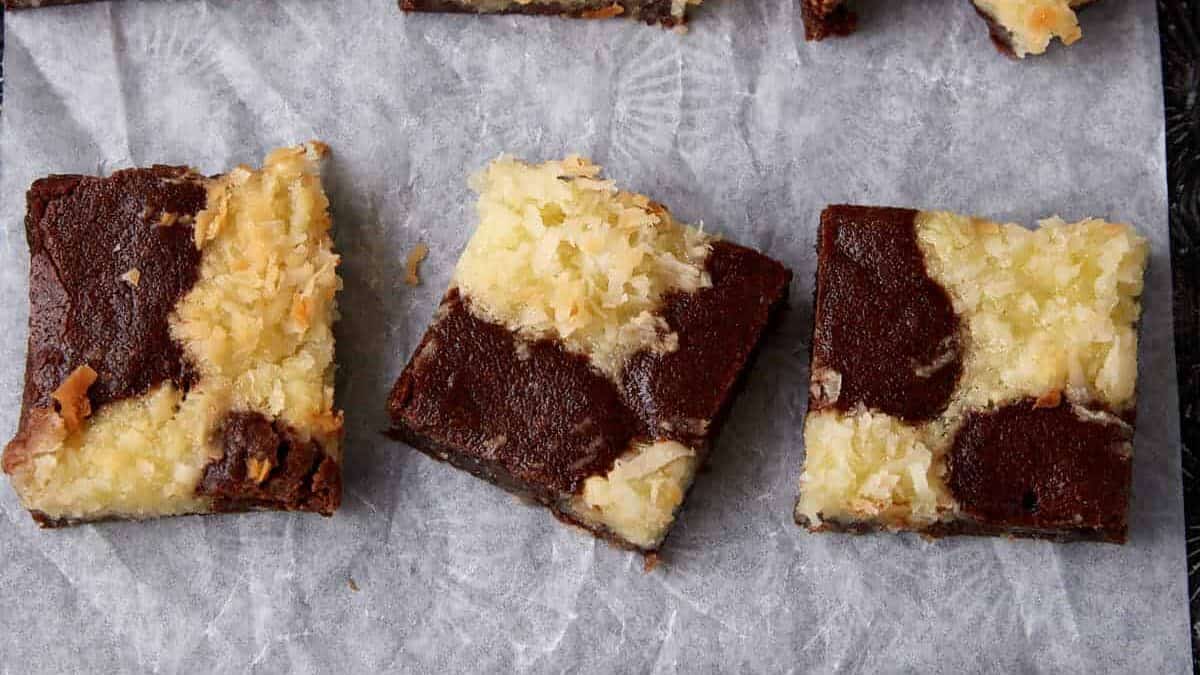 A batch of coconut brownies on parchment paper.