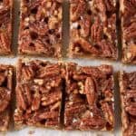 pecan pie bars sliced onto parchment paper.