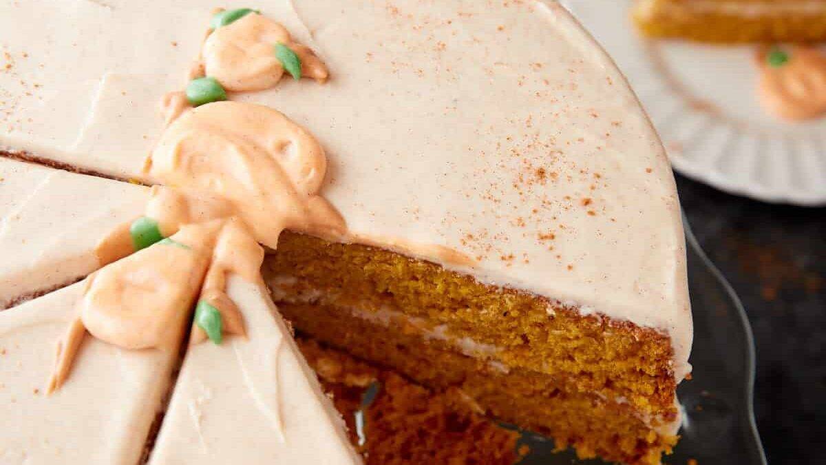 A pumpkin cake sliced with a a slice removed.