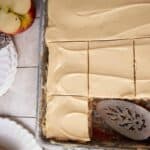 An apple cake cut in a pan with a spatula.