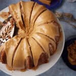 butterscotch frosting on an applesauce cake on a cake stand.