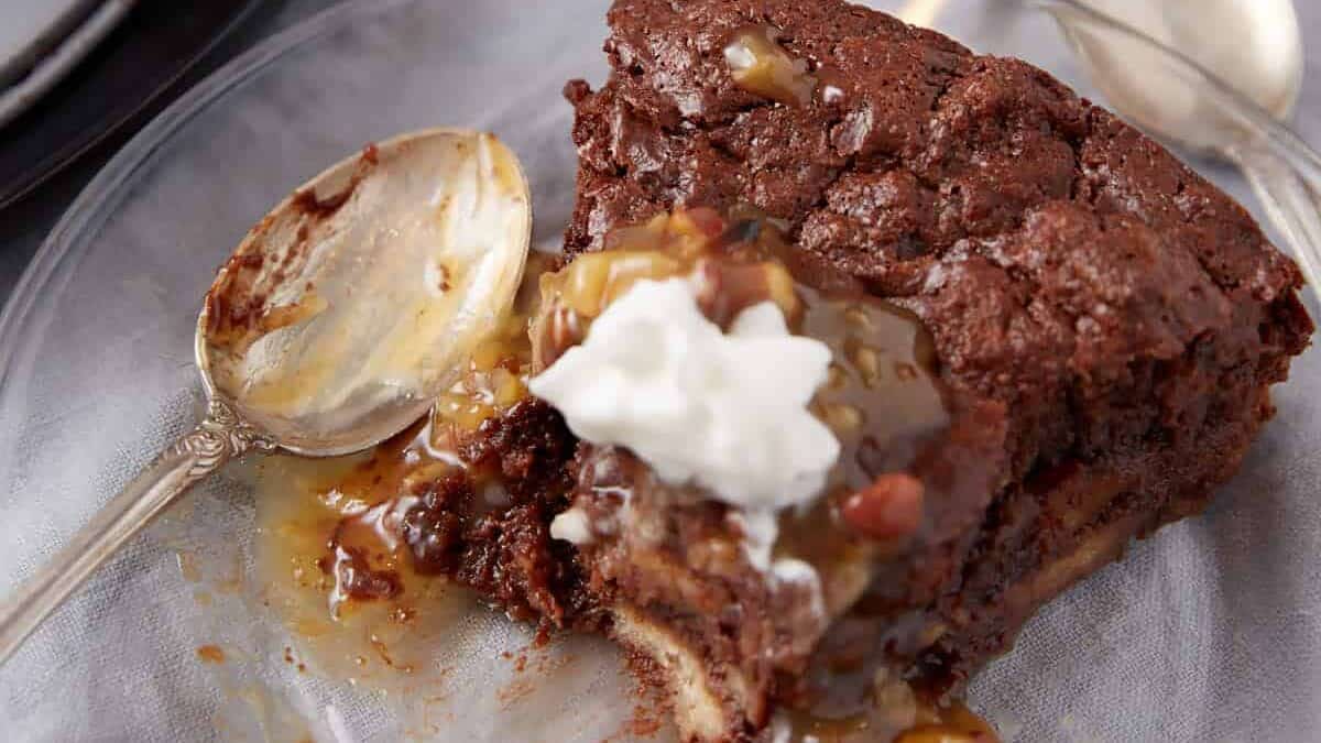 A slice of chocolate bread pudding with a bite taken.