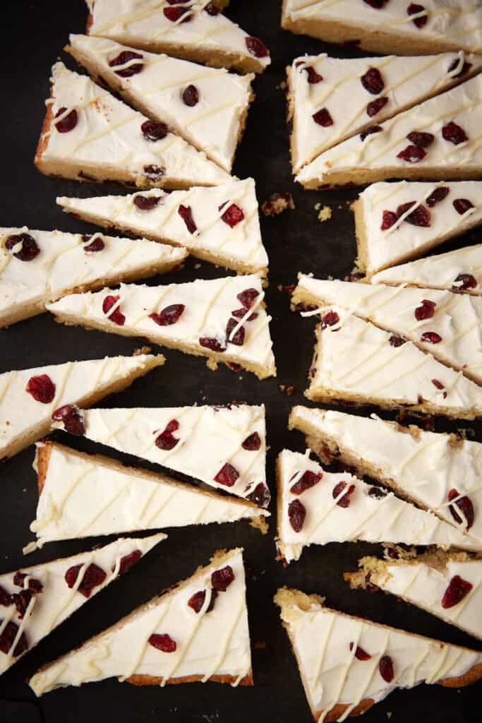 Overhead shot of multiple Cranberry Bliss Bars in a diagonal layout, highlighting the texture and toppings.