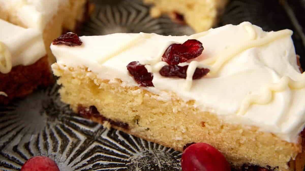 Triangular Cranberry Bliss Bars arranged on a dark board, ready to serve.