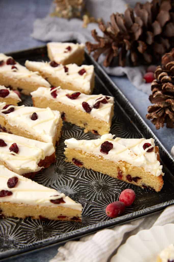 Cranberry Bliss Bars displayed on a tray with holiday decor in the background, perfect for gifting or entertaining.