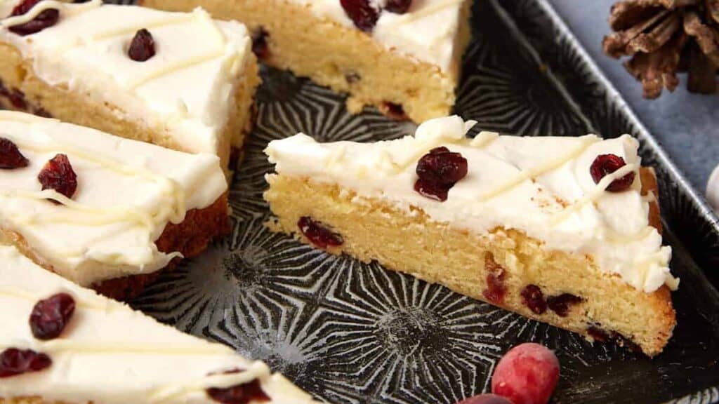 Cranberry Bliss Bars displayed on a tray with holiday decor in the background, perfect for gifting or entertaining.