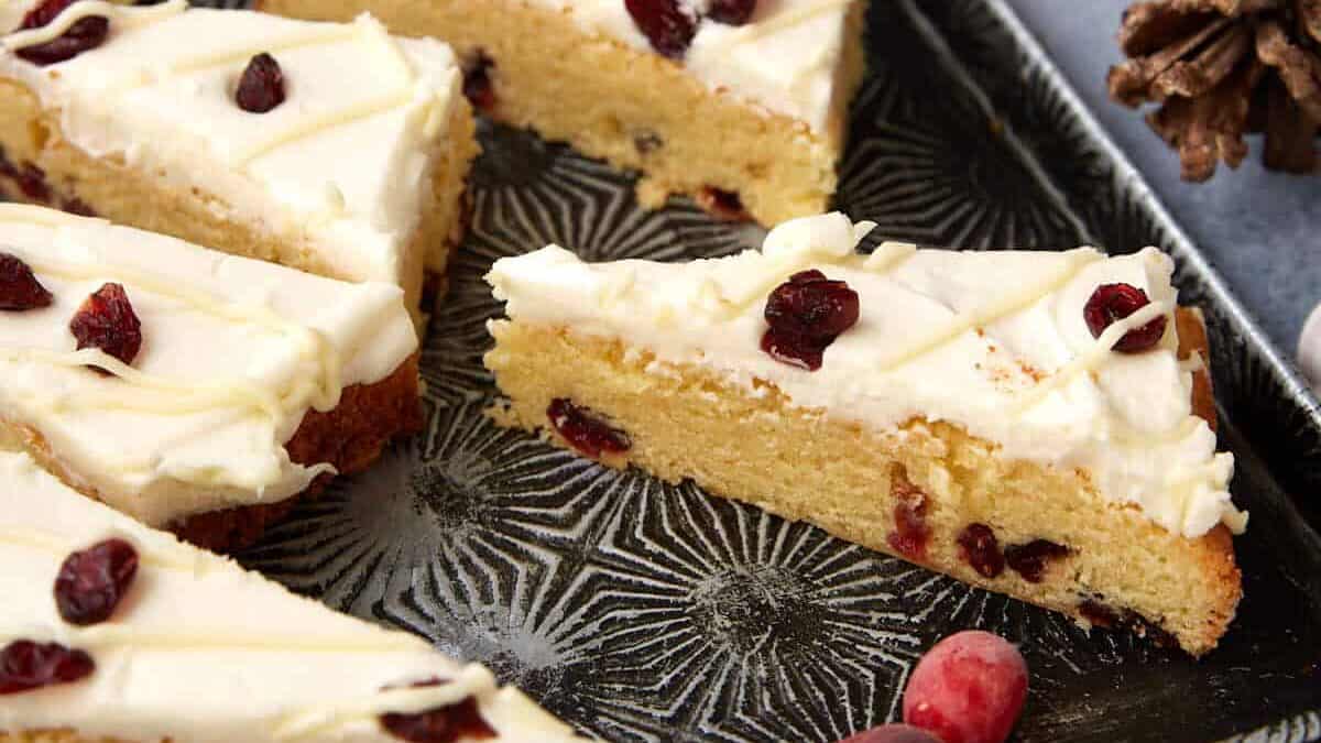 Cranberry Bliss Bars displayed on a tray with holiday decor in the background, perfect for gifting or entertaining.