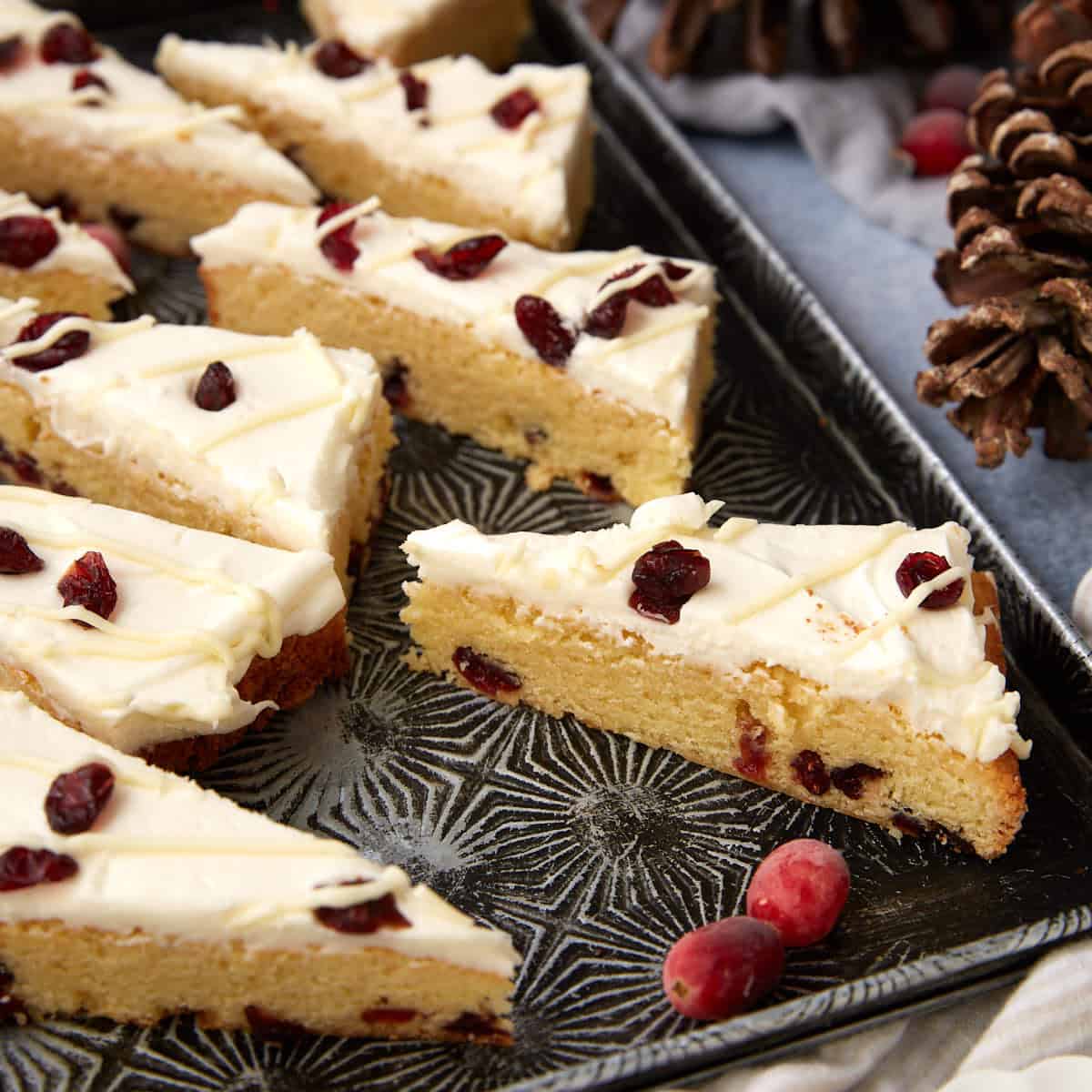 Cranberry Bliss Bars displayed on a tray with holiday decor in the background, perfect for gifting or entertaining.