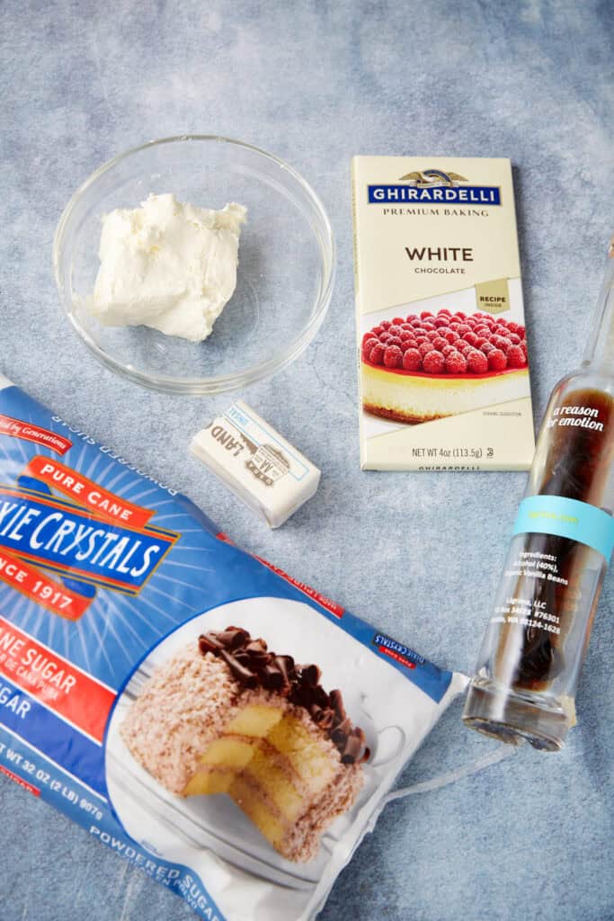 Ingredients for the frosting laid out, including cream cheese, butter, vanilla, powdered sugar, and a white chocolate bar.