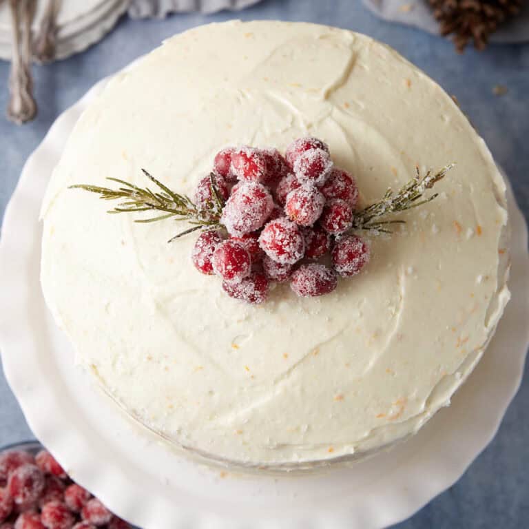 A cake topped with frosted cranberries.