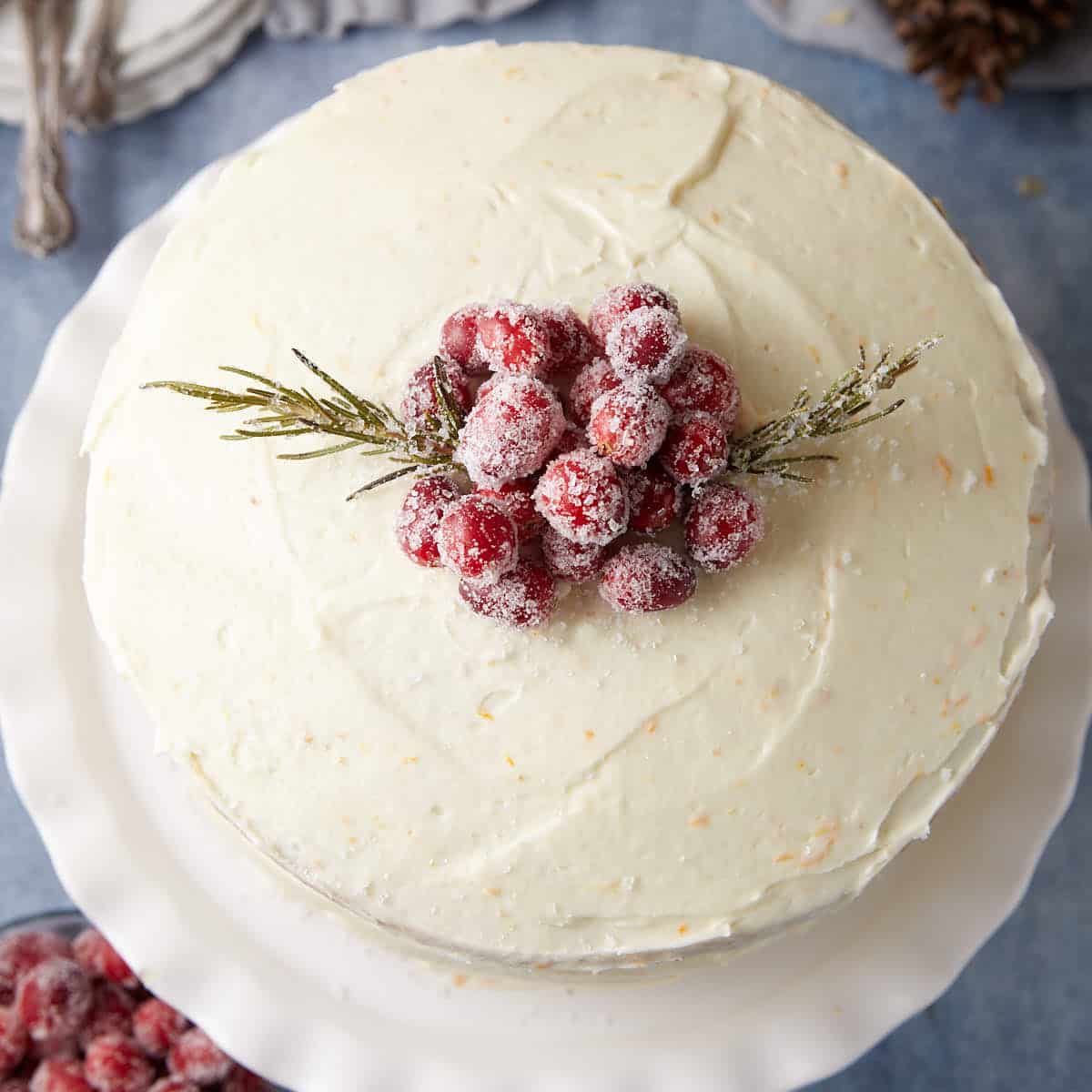 A cake topped with frosted cranberries.