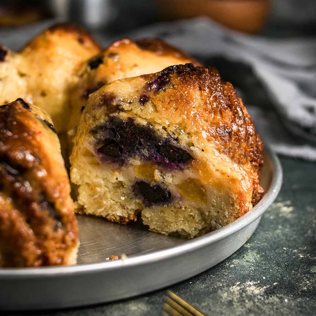 Close-up of the baked peach blueberry cake in the pan, highlighting the browned top and fruit-filled interior.