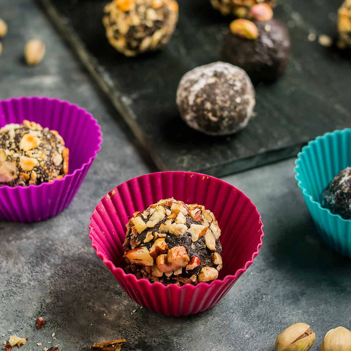 Chocolate truffles rolled and placed in colorful silicone candy cups with assorted coatings.