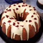 Close-up of the glazed cranberry orange bundt cake with dried cranberries scattered on top.