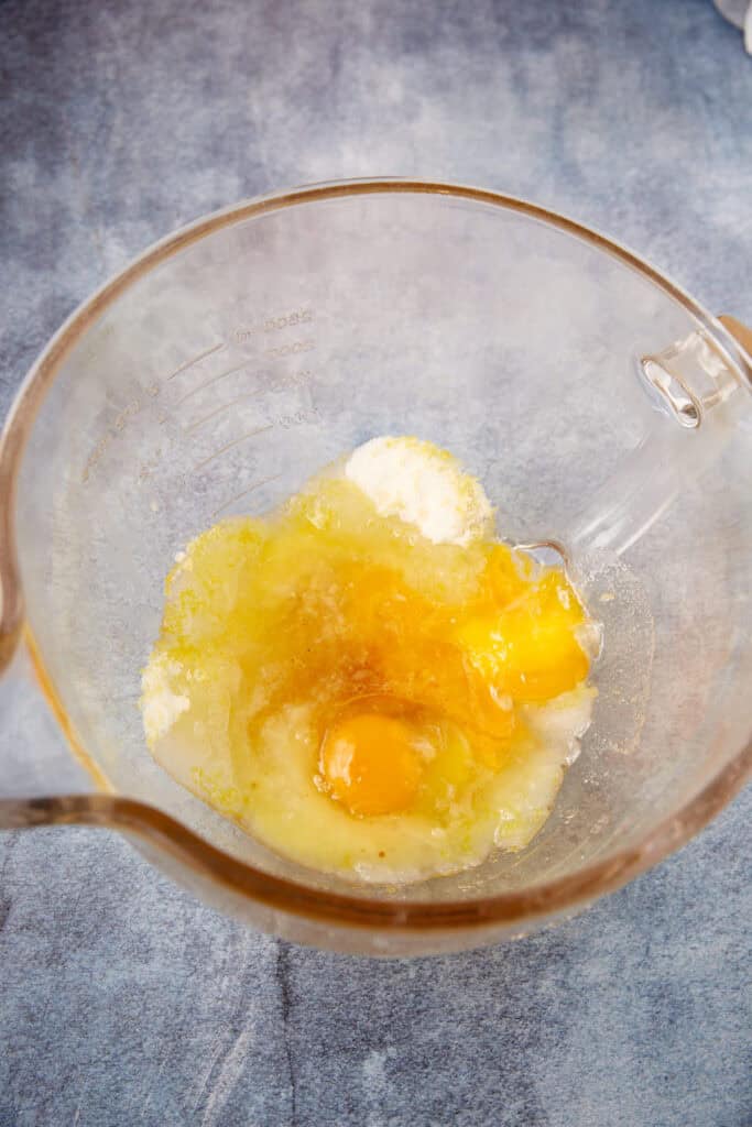 Lemon cookie dough in a mixing bowl with egg and vanilla added before mixing.