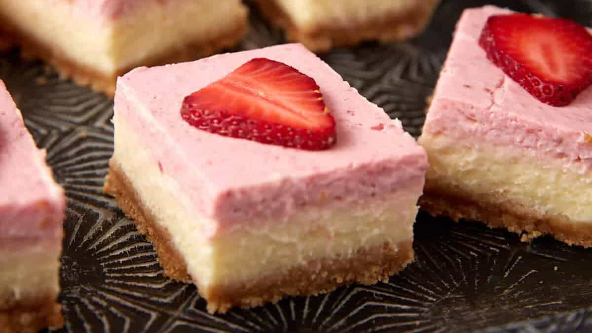 A dark tray with strawberry cream cheese bars.