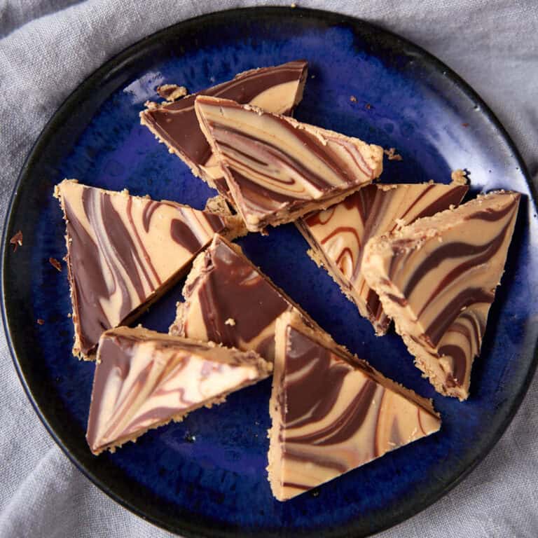 Tiger Butter triangles served on a dark blue plate.