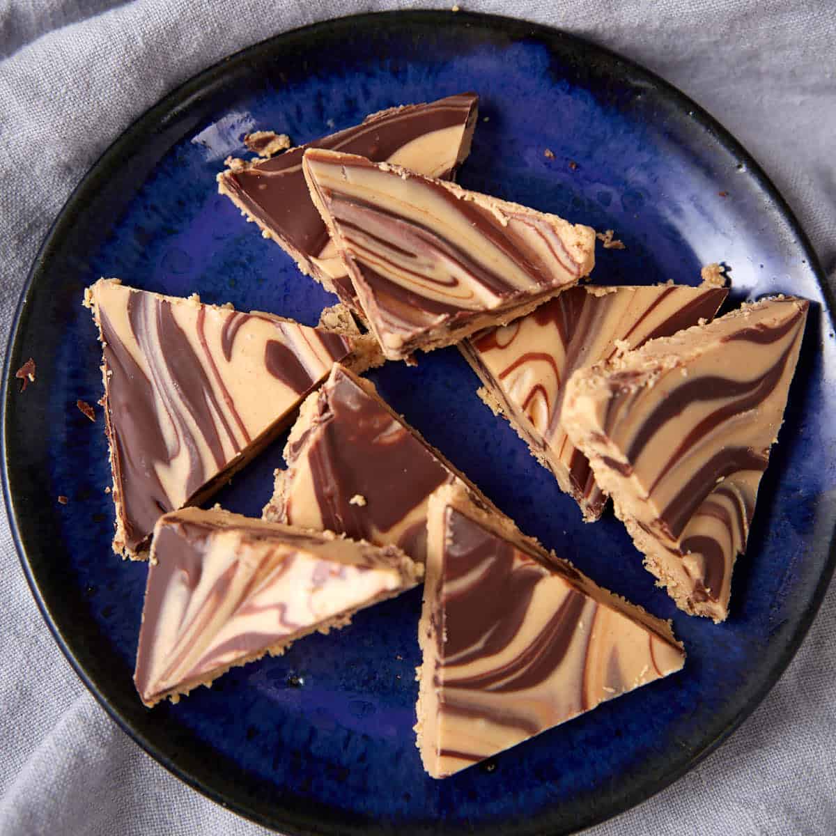 Tiger Butter triangles served on a dark blue plate.
