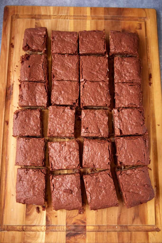German chocolate brownies cut into squares on a wooden board.