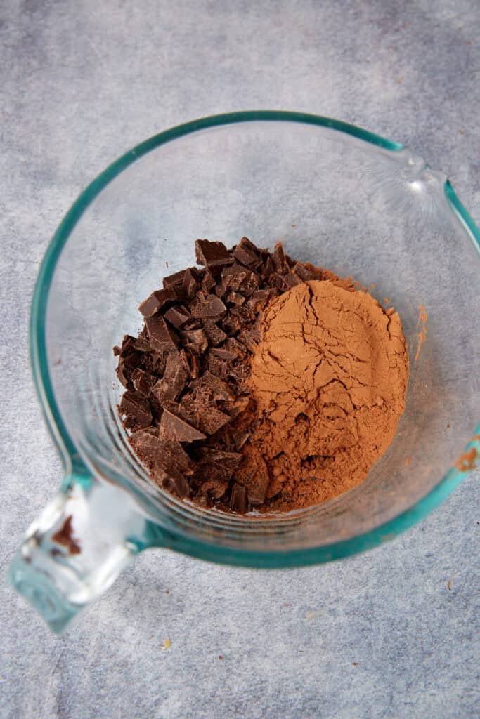 Chopped chocolate and cocoa powder in a glass measuring cup for German chocolate cake batter.