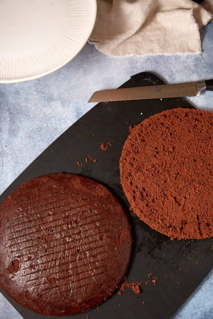 Assembled German chocolate cake on a cake stand with coconut pecan frosting between the layers and on top.
