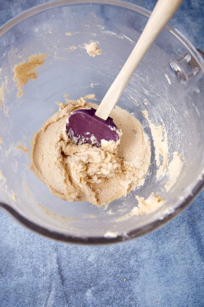 German chocolate cake batter in a mixing bowl with a spatula after the wet ingredients have been combined.